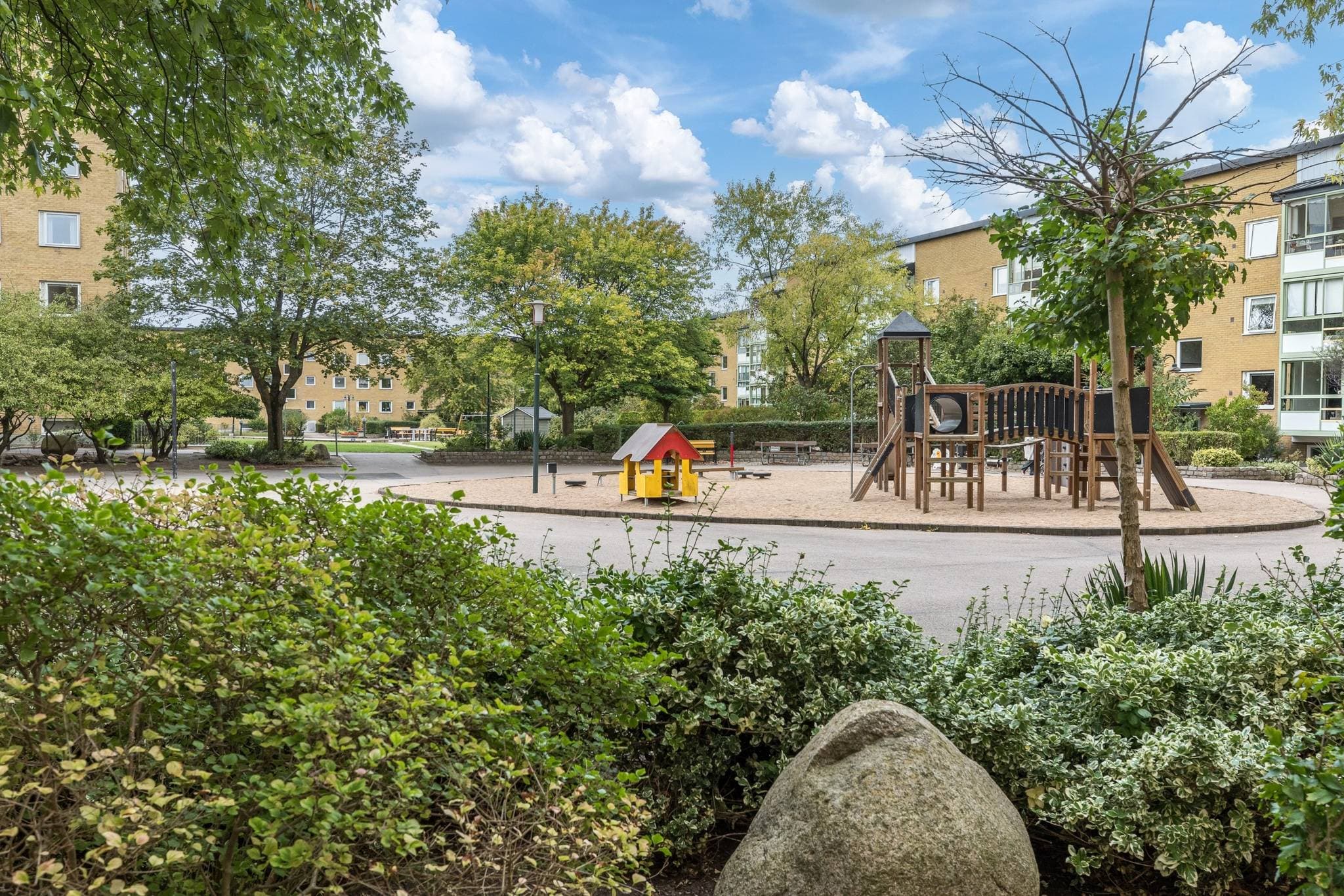 Grön gård med bostadshus i BRF Malmöhus 17